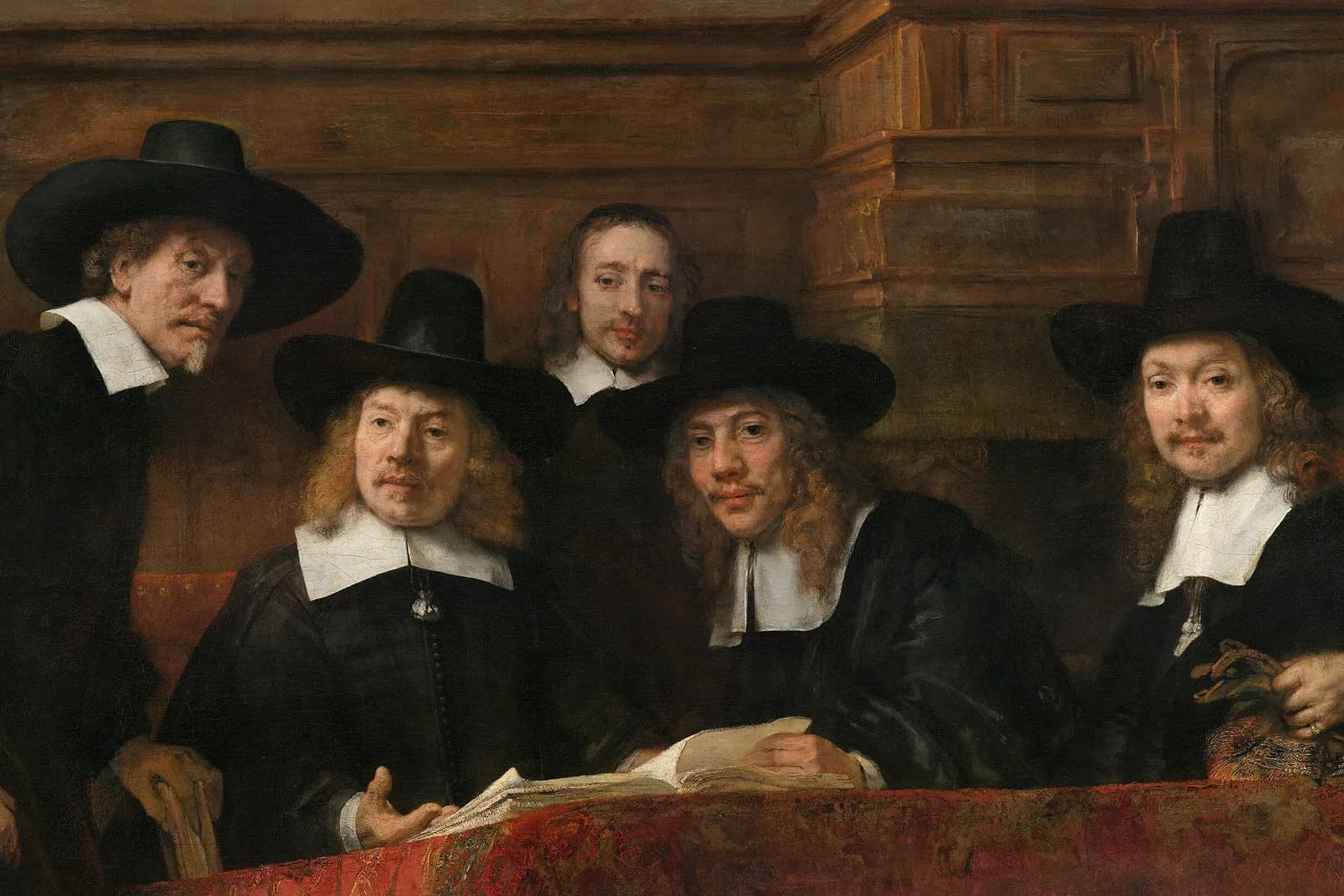 Detail of The Syndics of the Drapers' Guild by Rembrandt: guild officials in black hats reviewing an account book.
